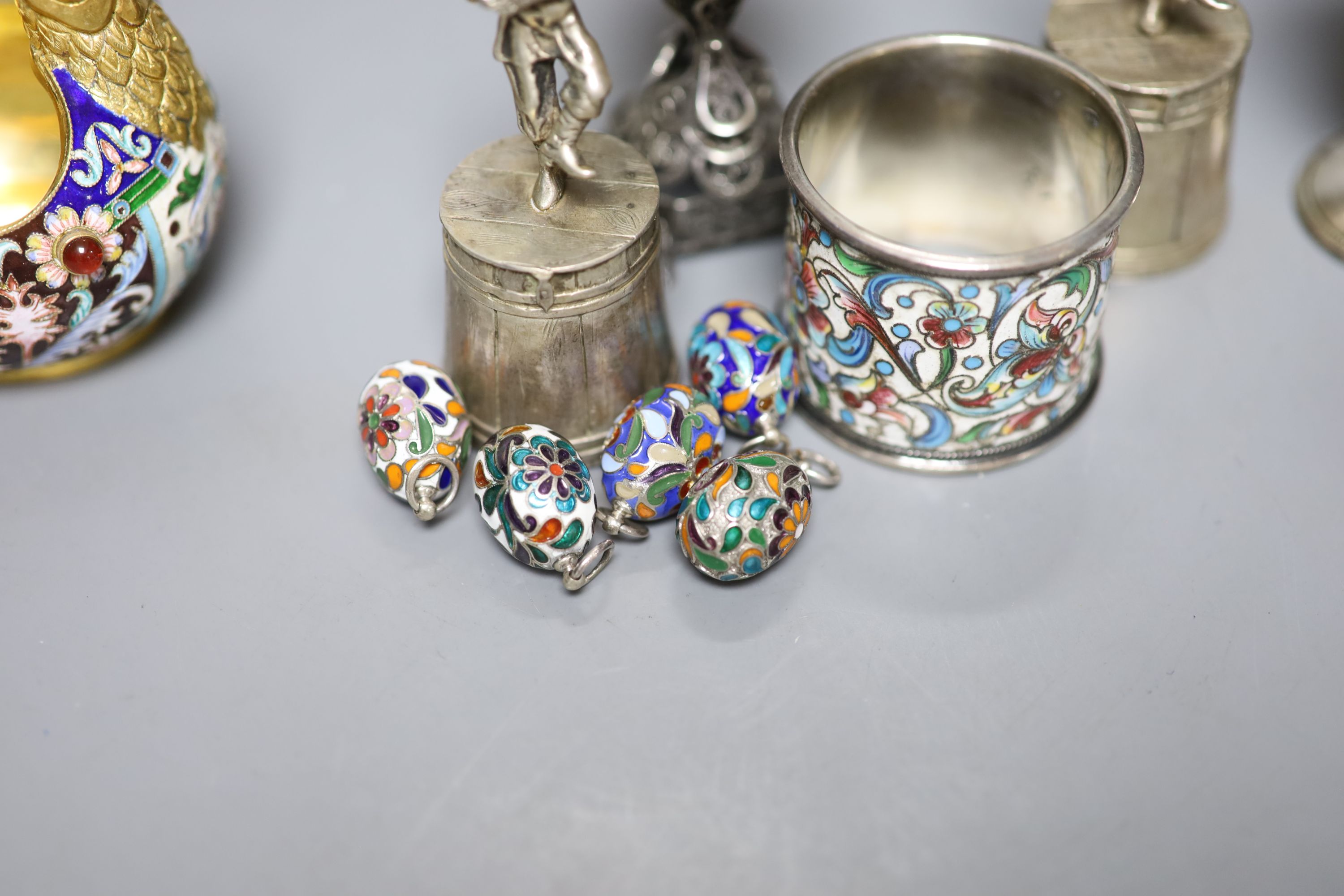 A group of Russian style white metal and enamel items including kovshs, egg pendants and small cups.
